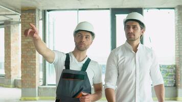 deux architectes sont en marchant le long de le bâtiment dans le progrès video