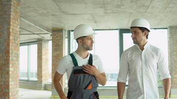 Two architects are walking along the building in progress video