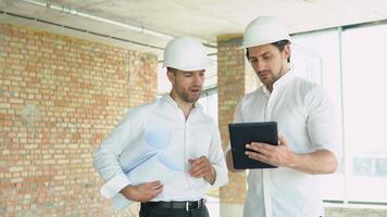 Two engineers discuss work with a tablet at the construction site video