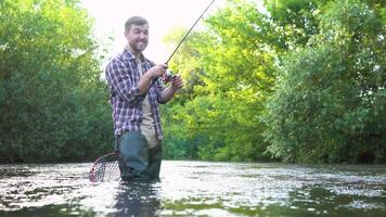 pescatore con pesca asta su il fiume. volare pesca per trota. estate vacanze e persone concetto video