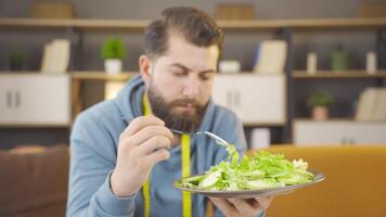 Man who is disgusted with eating salad. video