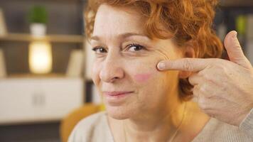 The woman who puts make-up on her face is happy. video