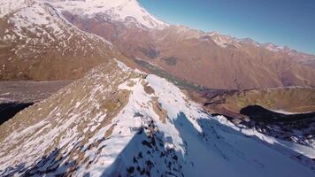 dyka från de topp av en klippig berg ner under de rocks. sport fpv Drönare flygande över klippig berg backe. hisnande antal fot av en dynamisk falla från en klippa video