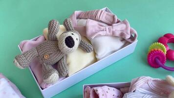 Baby and child clothes and knitted toys in carton box. video