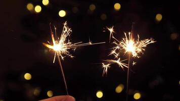 Two sparklers close up for New Year, Christmas, Birthday and others. On a blurred background with yellow light. video