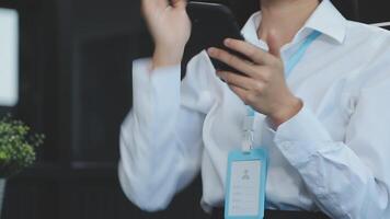 Asian businesswoman in formal suit in office happy and cheerful during using smartphone and working video