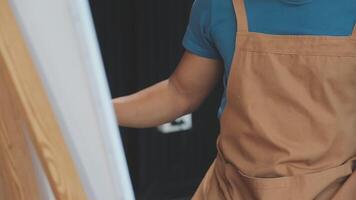 plus de le épaule sélectif concentrer coup de Masculin artiste en utilisant brosse tandis que ajouter Couleur peindre à crayon dessin sur Toile video