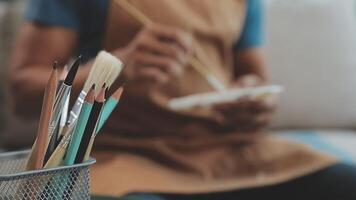 plus de le épaule sélectif concentrer coup de Masculin artiste en utilisant brosse tandis que ajouter Couleur peindre à crayon dessin sur Toile video