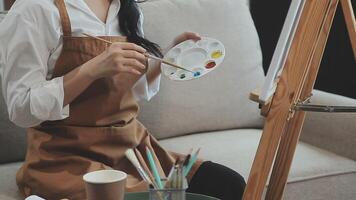 plus de le épaule sélectif concentrer coup de Masculin artiste en utilisant brosse tandis que ajouter Couleur peindre à crayon dessin sur Toile video