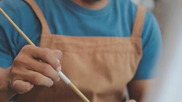 plus de le épaule sélectif concentrer coup de Masculin artiste en utilisant brosse tandis que ajouter Couleur peindre à crayon dessin sur Toile video