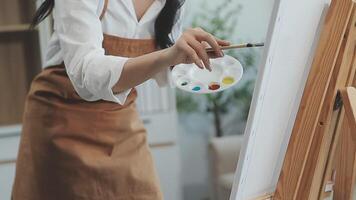 plus de le épaule sélectif concentrer coup de Masculin artiste en utilisant brosse tandis que ajouter Couleur peindre à crayon dessin sur Toile video