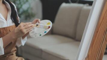 plus de le épaule sélectif concentrer coup de Masculin artiste en utilisant brosse tandis que ajouter Couleur peindre à crayon dessin sur Toile video