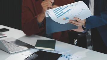 Financial analysts analyze business financial reports on a digital tablet planning investment project during a discussion at a meeting of corporate showing the results of their successful teamwork. video