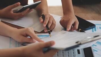 Financial analysts analyze business financial reports on a digital tablet planning investment project during a discussion at a meeting of corporate showing the results of their successful teamwork. video