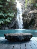 Focused stone in the foreground as an empty podium on a wooden deck with a waterfall in the background photo