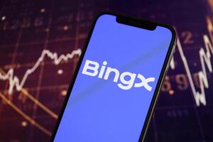 KYIV, UKRAINE - MARCH 15, 2024 BingX logo on iPhone display screen and crypto currency value charts photo