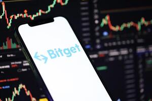 KYIV, UKRAINE - MARCH 15, 2024 Bitget logo on iPhone display screen and crypto currency value charts photo