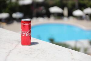 ANTALYA, TURKEY - MAY 18, 2021 Can of Coca Cola on bar desk, close up. Coca Cola Company is the leading manufacturer of soda drinks photo