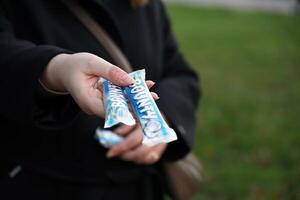 KYIV, UKRAINE - OCTOBER 31, 2023 Bounty chocolate bars with cocoa flavor filling in female hand. Bounty chocolate bar is a brand of American Mars Inc photo