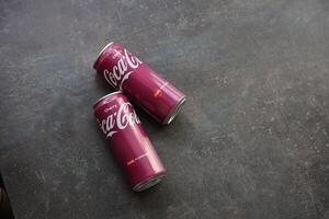 KYIV, UKRAINE - 4 MAY, 2023 Coca cola soft drinks brand tin cans with cherry flavour photo