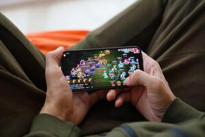 Fantasy Westward Journey mobile iOS game on iPhone 15 smartphone screen in male hands during mobile gameplay photo