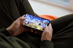 Fate Grand Order mobile iOS game on iPhone 15 smartphone screen in male hands during mobile gameplay photo