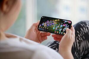 Fantasy Westward Journey mobile iOS game on iPhone 15 smartphone screen in female hands during mobile gameplay photo