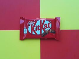 KHARKIV, UKRAINE - JANUARY 2, 2021 Kit Kat by Nestle chocolate covered wafer on bright color photo