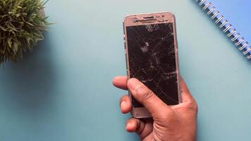 close-up van de hand van de man met gebroken slimme telefoon. video