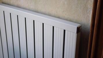 White radiator on grey white wall. apartment heating installation system, video