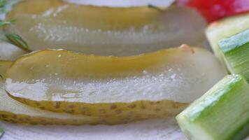 a close up of a pickle on a plate with tomatoes video