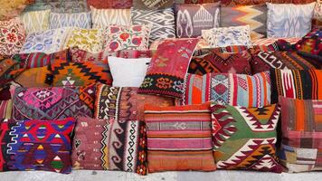 Colourful cushions and carpet on display for sale in a traditional Turkish Bazaar. video