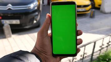 Jeune homme main en utilisant intelligent téléphone avec vert écran avec Taxi sur Contexte video