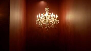 Antique crystal chandelier on a dark background. Beautiful modern chandelier in a red interior. photo