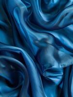 Abstract composition of deep teal fabric folds forming mesmerizing contours and hypnotic patterns, showcasing the rich color and sculptural qualities. photo