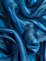 Abstract composition of deep teal fabric folds forming mesmerizing contours and hypnotic patterns, showcasing the rich color and sculptural qualities. photo