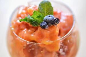 home made ice cream with raspberry, blackberry, mango fruits served in wine glasses. photo