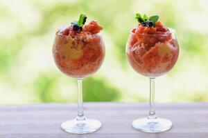 home made ice cream with raspberry, blackberry, mango fruits served in wine glasses. photo