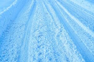 Texture of a snowy road with traces of car tires. photo