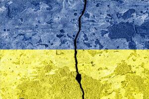 Ukrainian flag on cracked concrete wall. The concept of crisis, default, economic collapse, pandemic, conflict, terrorism or other problems in the country. photo