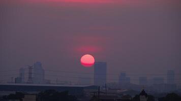 imágenes de rojo Dom conjuntos detrás el silueta de ciudad edificios, puesta de sol video