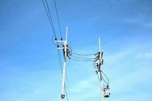 Street light with Power poles and tangled wires on blue sky in Thailand photo