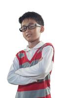 un indonesio 10 años antiguo chico vistiendo rojo raya suéter y lentes con confianza brazo actitud foto