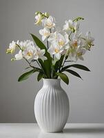 blanco orquídeas en un florero en un gris antecedentes. foto