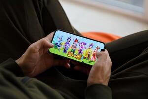 Fantasy Westward Journey mobile iOS game on iPhone 15 smartphone screen in male hands during mobile gameplay photo