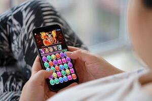 Puzzle and dragons mobile iOS game on iPhone 15 smartphone screen in female hands during mobile gameplay photo