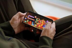 Puzzle and dragons mobile iOS game on iPhone 15 smartphone screen in male hands during mobile gameplay photo