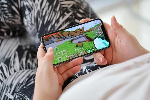Minecraft móvil ios juego en iphone 15 teléfono inteligente pantalla en hembra manos durante móvil Como se Juega foto