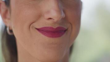 mond met fuchsia lippenstift van een vrouw glimlachen een beetje video