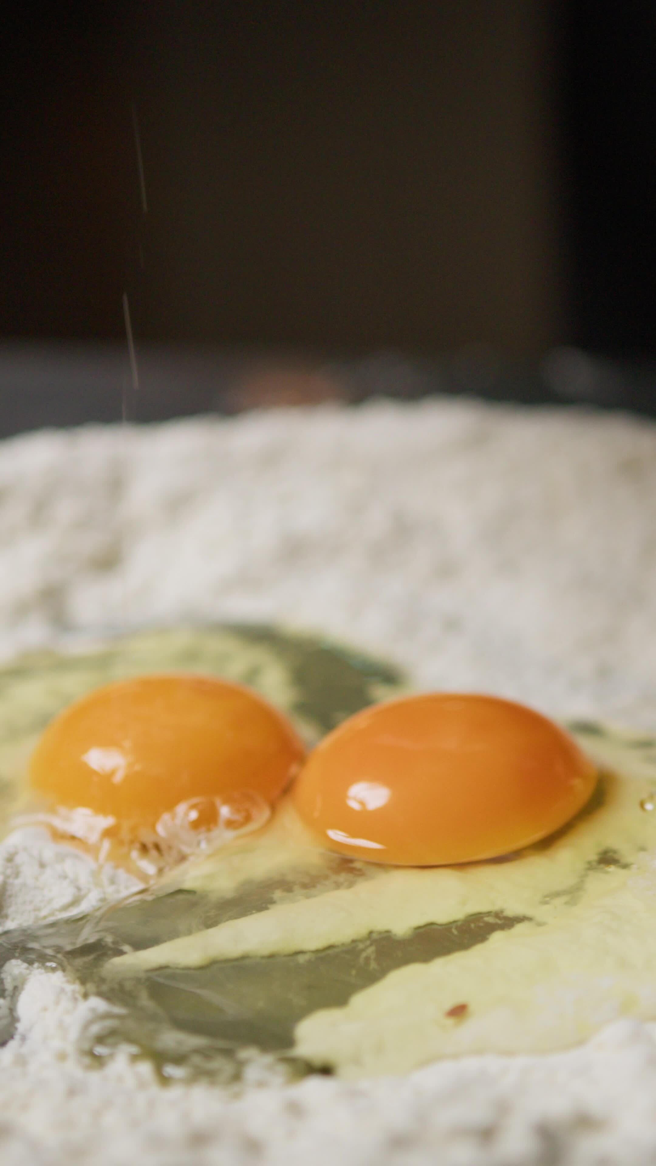 Hand Of Chef Cracking Eggs Into Flour For Dough Pasta Tagliatelle